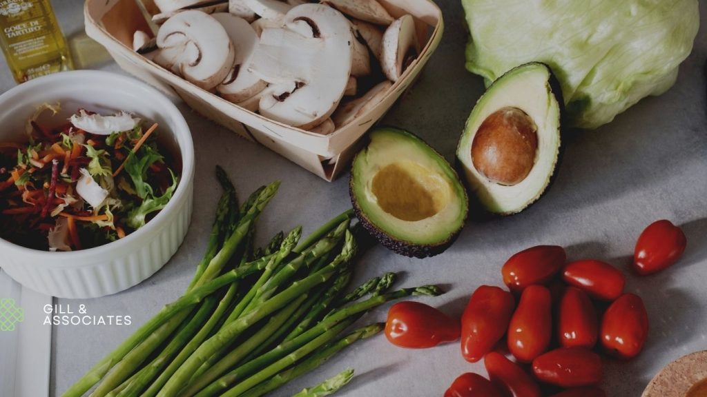 Healthy and fresh fitness food ingredients including avocado, mushrooms, asparagus, lettuce, salad, and tomatoes for a balanced health and fitness lifestyle.
